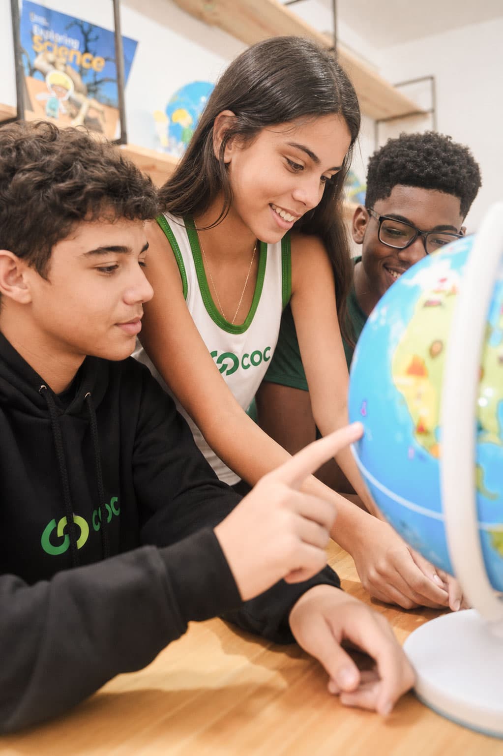Alunos do Colégio COC observando um globo terrestre em atividade em grupo