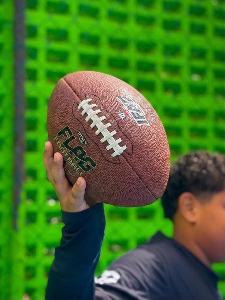 Aluno do Colégio COC erguendo uma bola de flag football