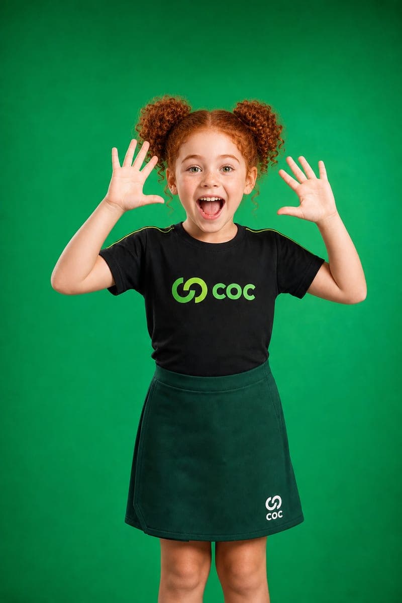 Aluna do COC de mãos levantadas, com o uniforme da escola